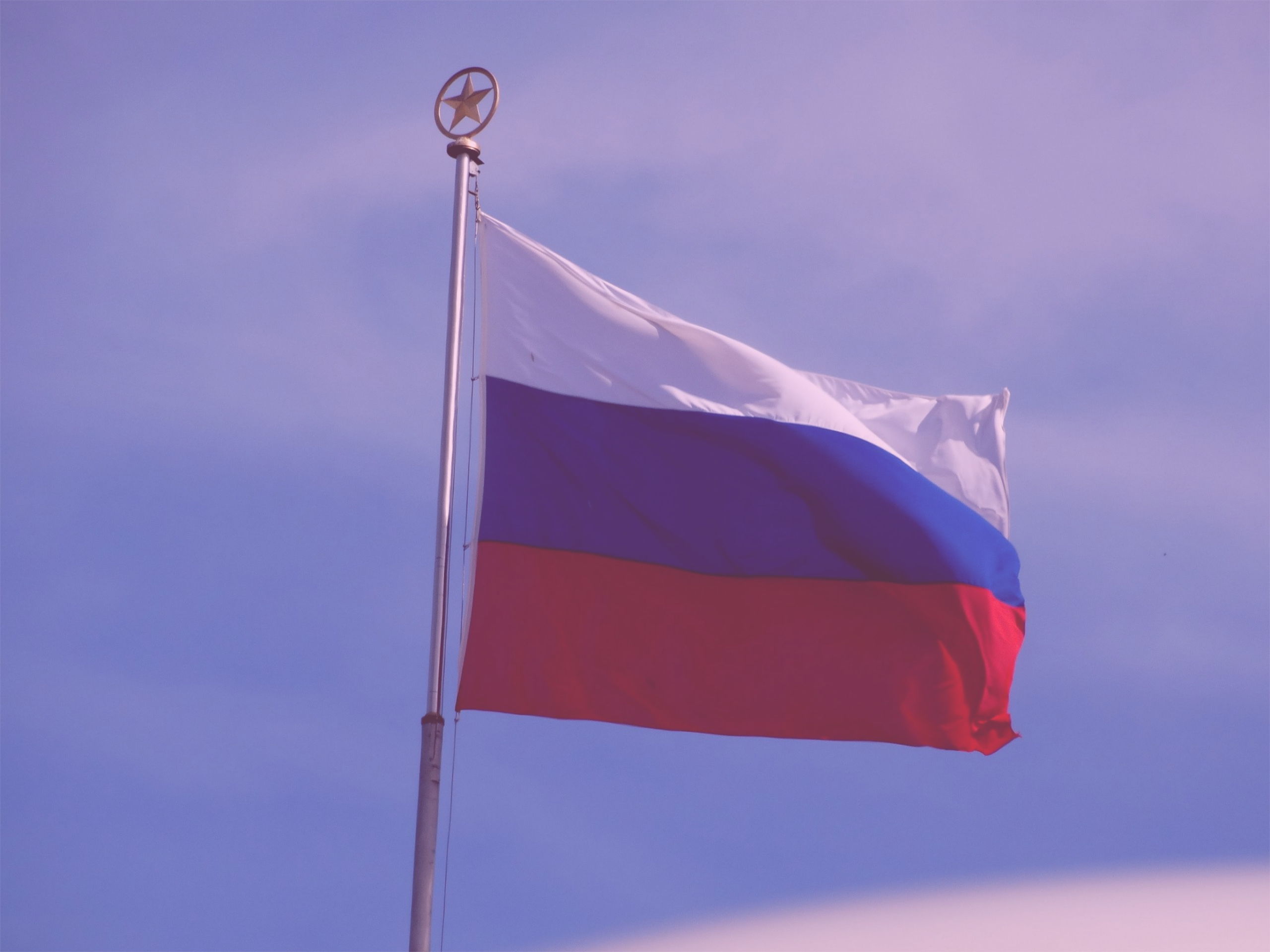 Photo: "Flag In The Wild Russian Federation (164796773)", by Santiago Quintero licensed under CC BY 3.0. Hue modified from the original